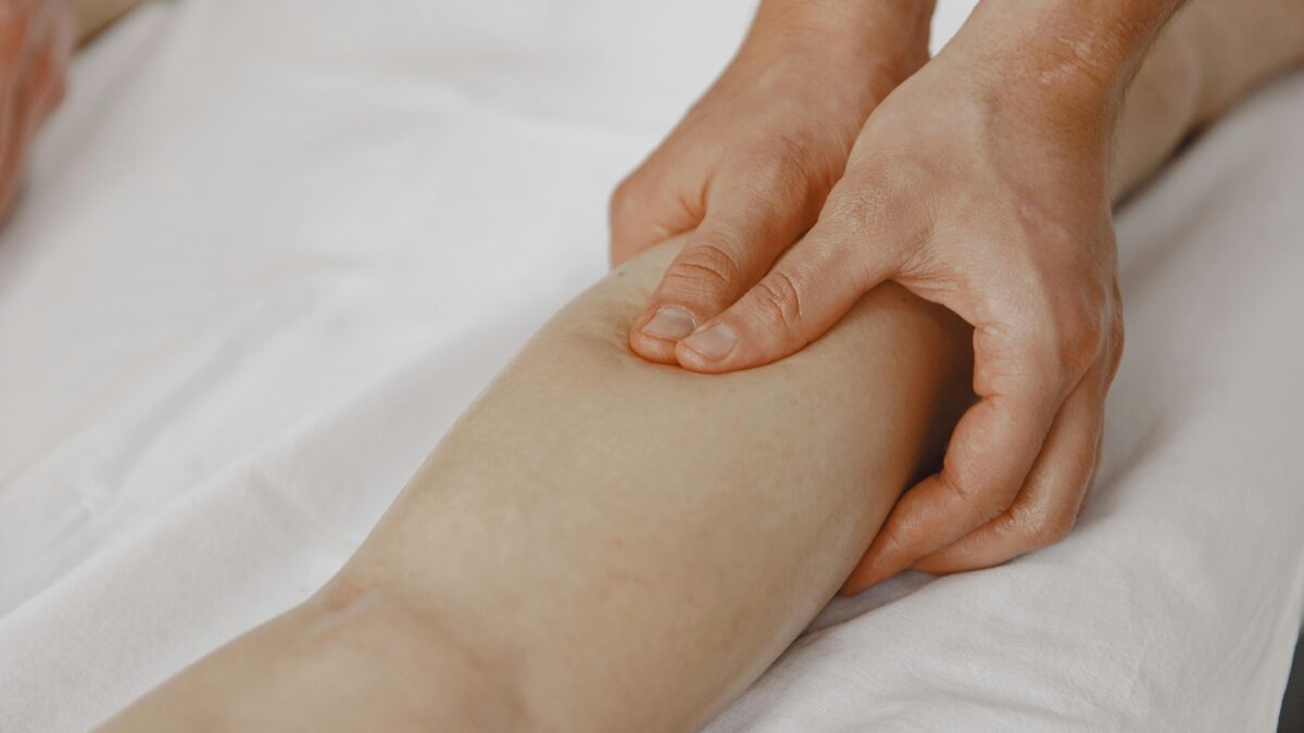 Masaje de drenaje linfático manual en la pierna para aliviar la retención de líquidos y piernas cansadas en verano.
