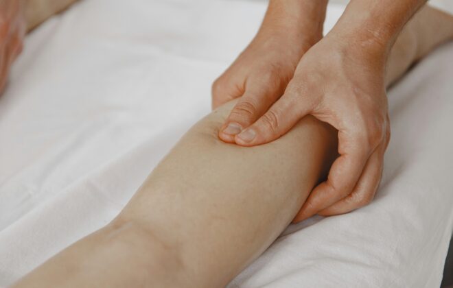Masaje de drenaje linfático manual en la pierna para aliviar la retención de líquidos y piernas cansadas en verano.