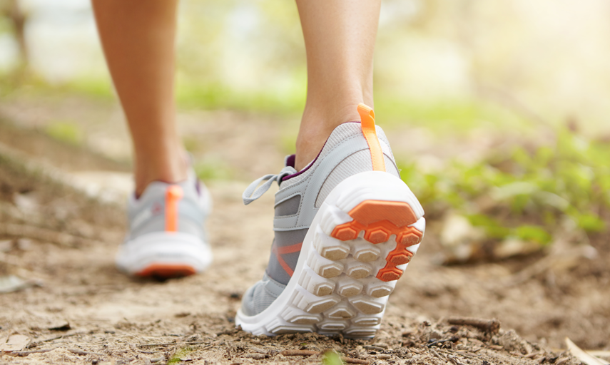 Mujer caminando con zapatillas cómodas y transpirables que favorecen la no aparición de ampollas en los pies.