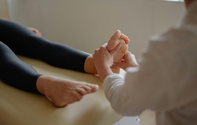 Podólogo y fisioterapeuta en Las Águilas Aluche tratando pie de paciente con dedos en garra