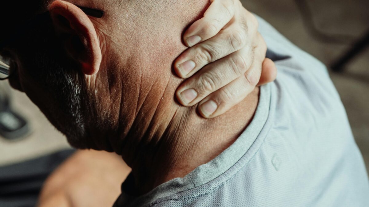 Persona mayor tocándose el cuello con gesto de dolor articular