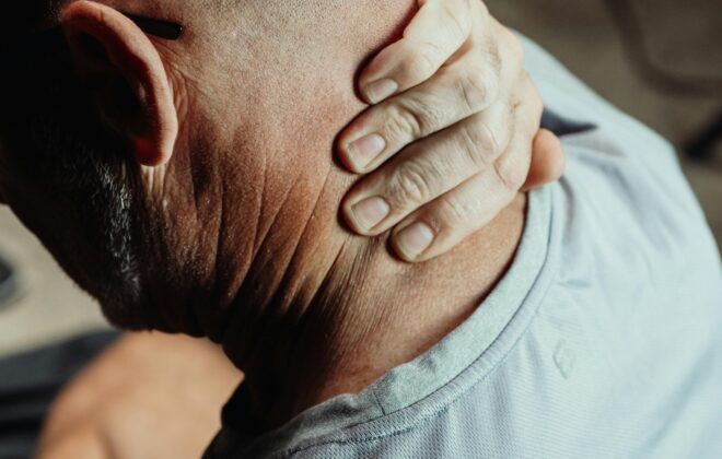 Persona mayor tocándose el cuello con gesto de dolor articular