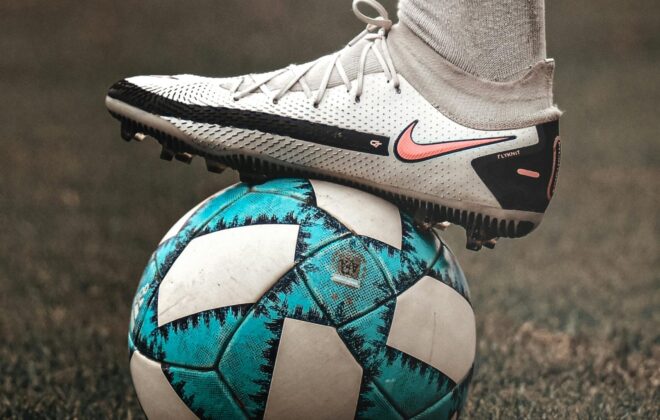 Pie con bota de fútbol sobre balón, ilustrando lesiones comunes en pies de futbolista